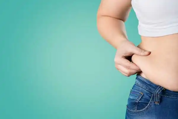 Image of woman pinching her love handles to show weight gain Eccles